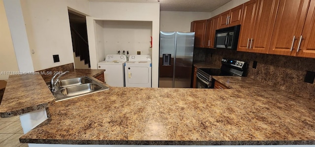 kitchen featuring separate washer and dryer, sink, kitchen peninsula, and black appliances