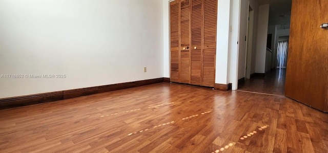 unfurnished bedroom with wood-type flooring and a closet