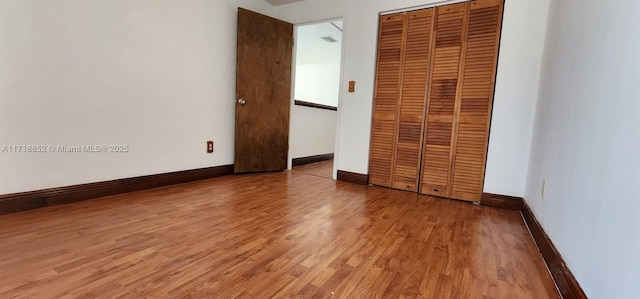 unfurnished bedroom featuring hardwood / wood-style floors and a closet