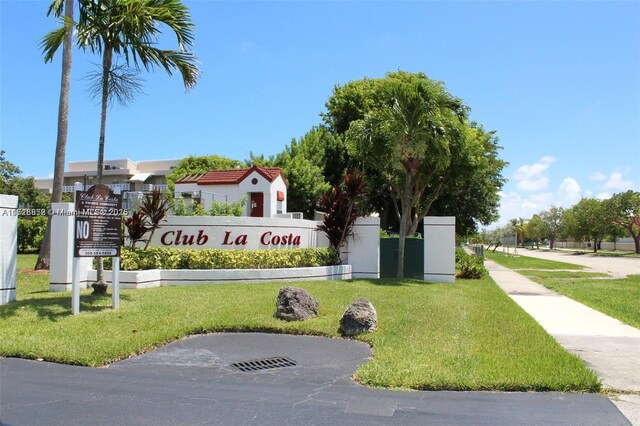 community sign featuring a lawn