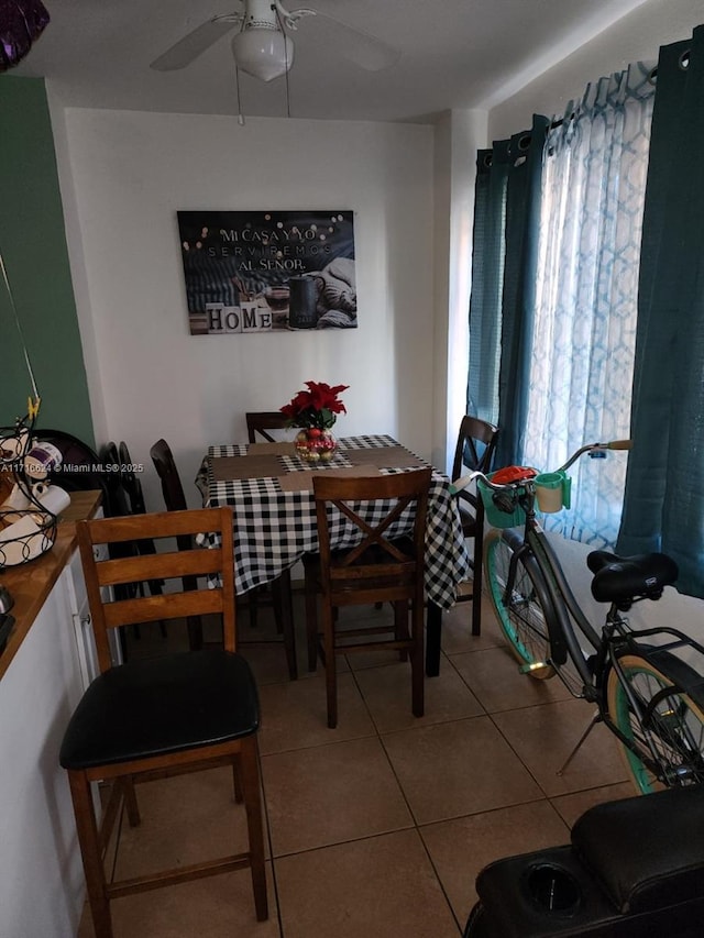 tiled dining space featuring ceiling fan