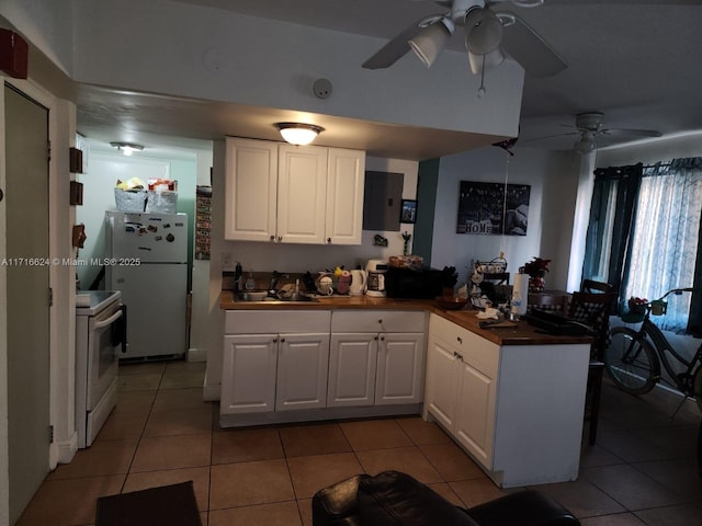 kitchen featuring light tile patterned floors, white appliances, white cabinetry, and sink