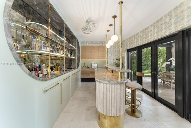 bar featuring stone counters and french doors