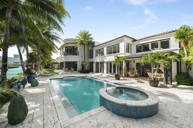 view of swimming pool featuring a patio area and an in ground hot tub