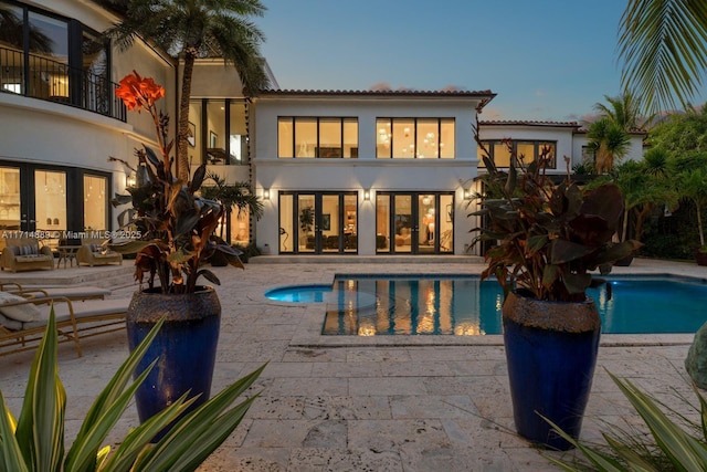 pool at dusk with a patio area