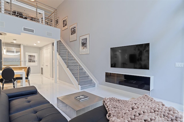 living room with tile patterned floors and a high ceiling