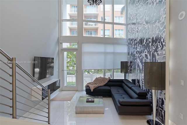 living room with a high ceiling, a wealth of natural light, and tile patterned flooring