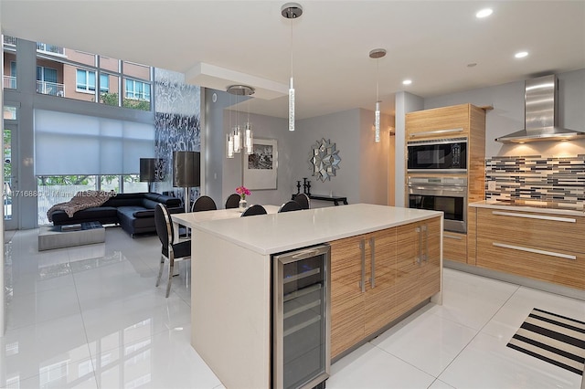 kitchen with tasteful backsplash, beverage cooler, stainless steel oven, light tile patterned floors, and wall chimney exhaust hood