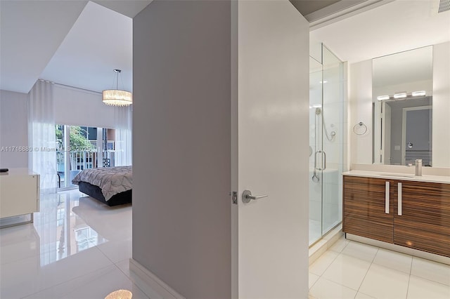 bathroom with tile patterned floors, a chandelier, a shower with door, and vanity