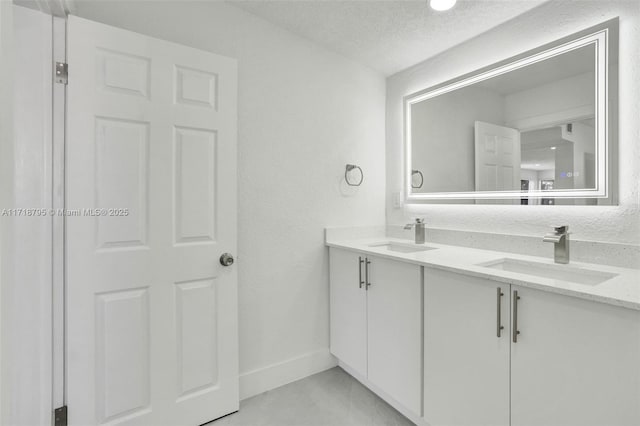 bathroom with tile patterned flooring, vanity, and a textured ceiling