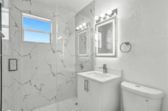 bathroom featuring vanity, toilet, and a shower with shower door