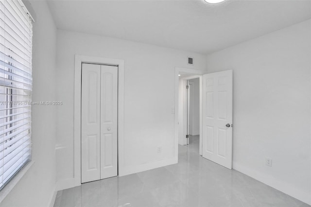 unfurnished bedroom with multiple windows and a closet