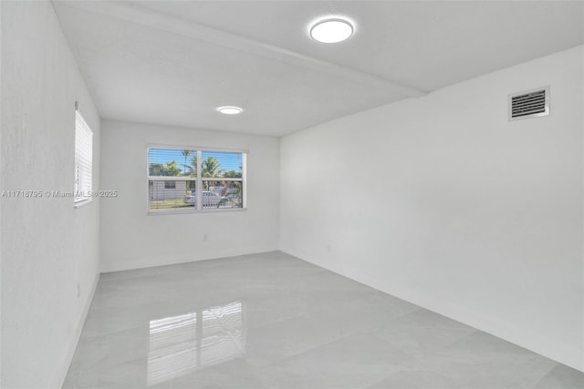 unfurnished room featuring beam ceiling