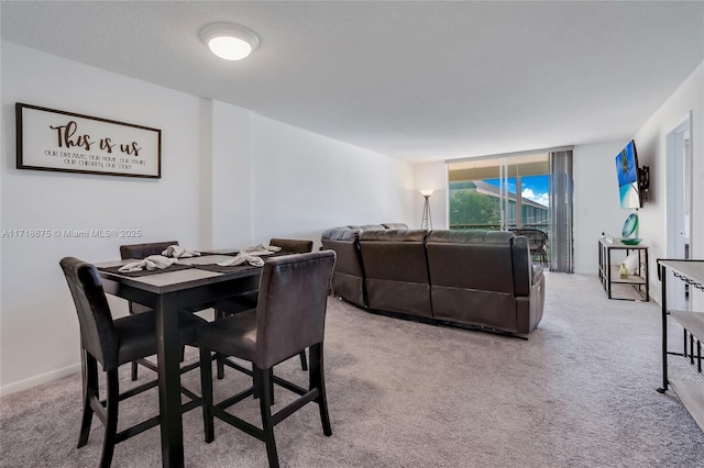 dining area with light carpet and floor to ceiling windows