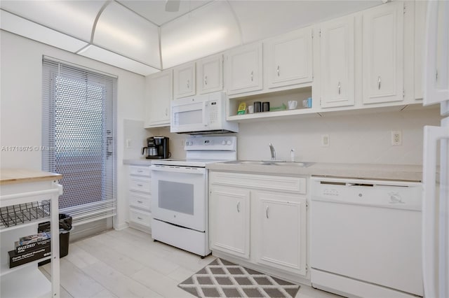 kitchen featuring backsplash, sink, white cabinets, and white appliances