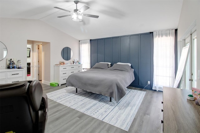 bedroom featuring ceiling fan, light hardwood / wood-style flooring, and lofted ceiling