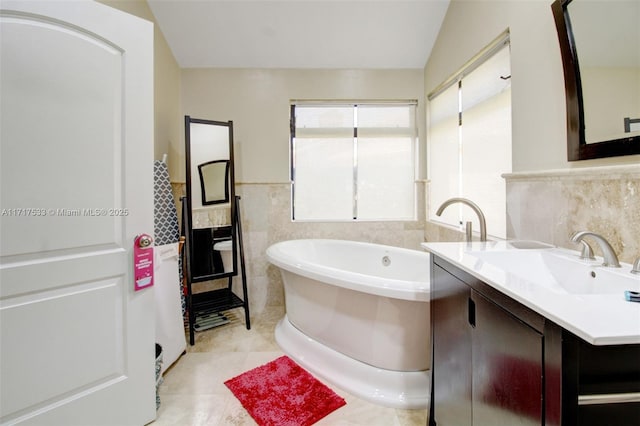 bathroom with vanity, vaulted ceiling, tile walls, tile patterned flooring, and a bathing tub