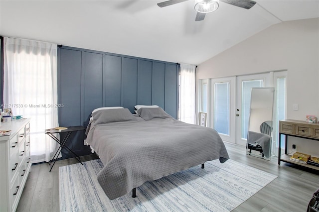 bedroom with french doors, light hardwood / wood-style floors, ceiling fan, and lofted ceiling