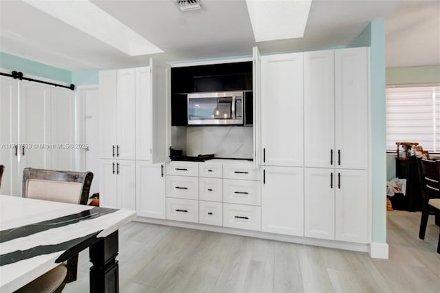 kitchen with white cabinets and light hardwood / wood-style flooring