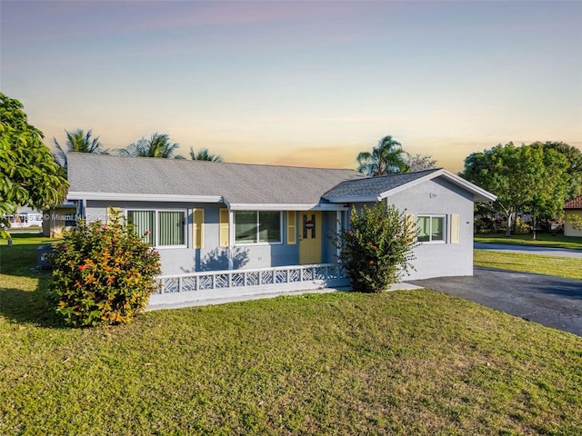 single story home with a lawn