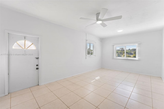 empty room with ceiling fan and light tile patterned flooring