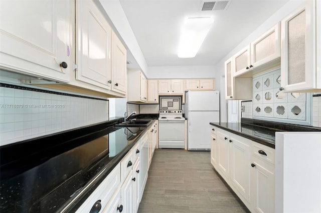 kitchen featuring decorative backsplash, dishwasher, and white cabinets