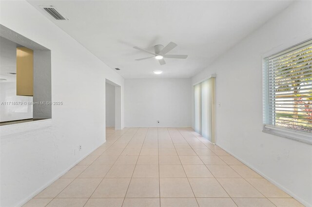 unfurnished living room featuring light tile patterned floors, ceiling fan with notable chandelier, and plenty of natural light