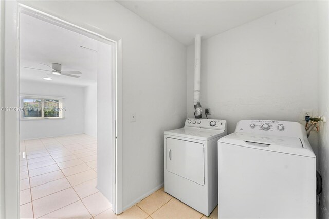 laundry room with ceiling fan, washer and dryer, and light tile patterned floors