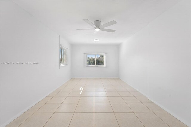 tiled spare room featuring ceiling fan