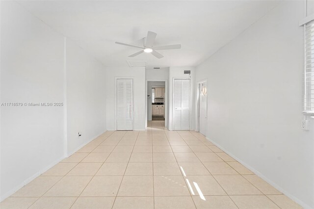 tiled spare room featuring ceiling fan