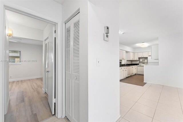 unfurnished bedroom with ceiling fan, a closet, and light tile patterned floors