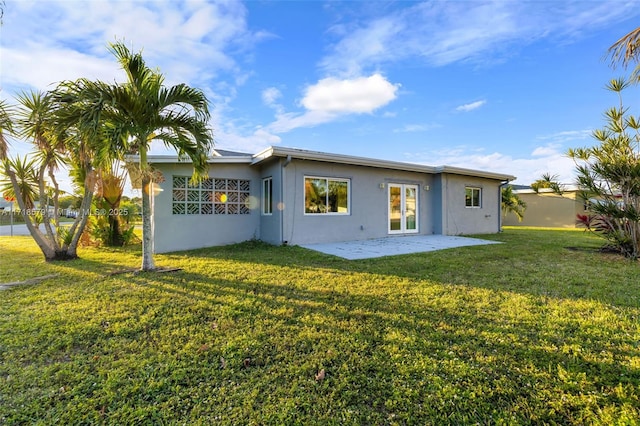 rear view of house featuring a yard and a patio