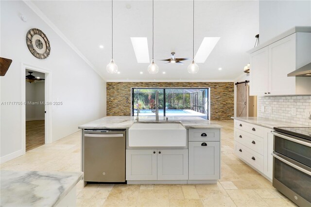 kitchen featuring ceiling fan, ornamental molding, appliances with stainless steel finishes, and a sink