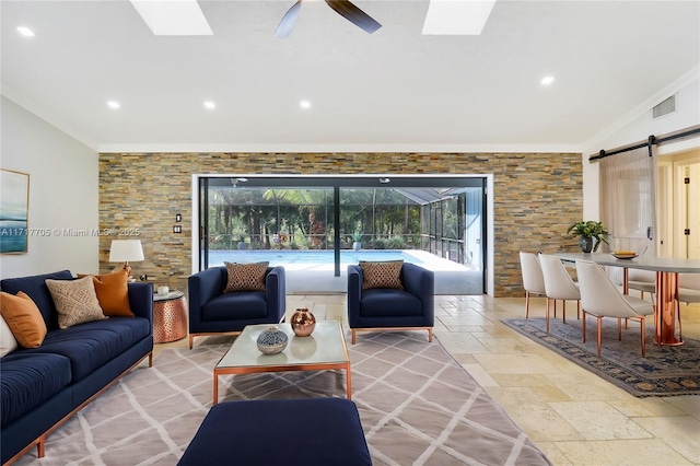 living area featuring stone tile floors, a ceiling fan, a wealth of natural light, and ornamental molding