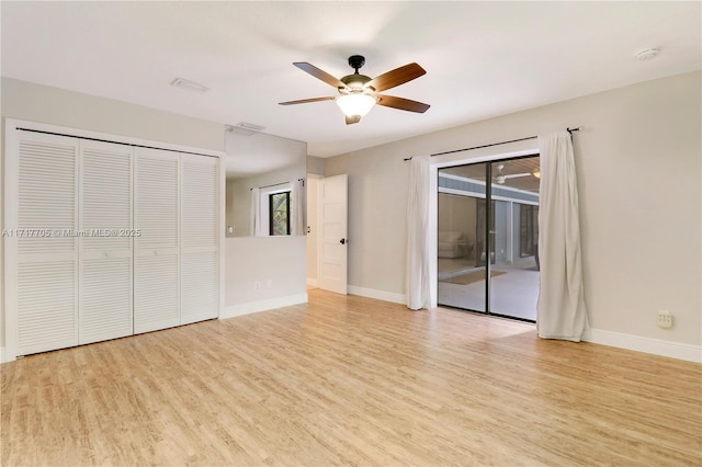 unfurnished bedroom with visible vents, access to outside, wood finished floors, a closet, and baseboards