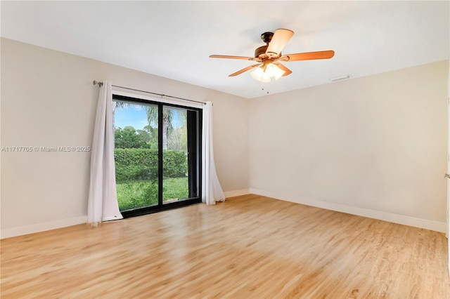 empty room with light wood finished floors, visible vents, a ceiling fan, and baseboards