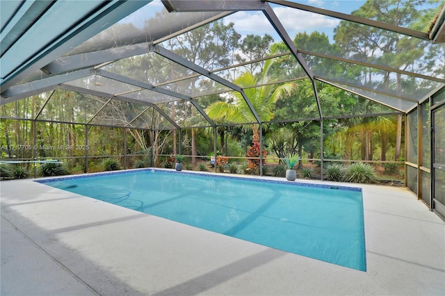 outdoor pool featuring glass enclosure and a patio area