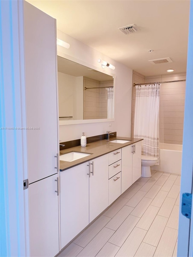 full bathroom with vanity, shower / bath combo, and toilet