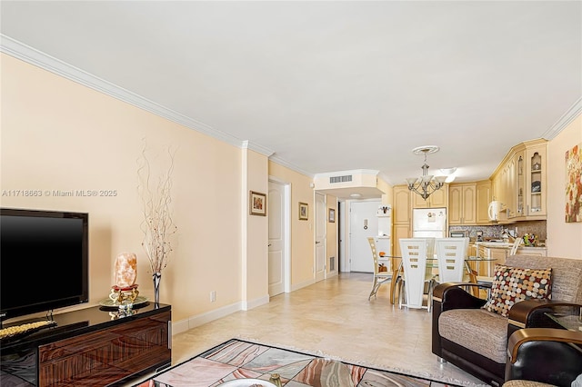 living room with ornamental molding, light tile patterned floors, and a chandelier