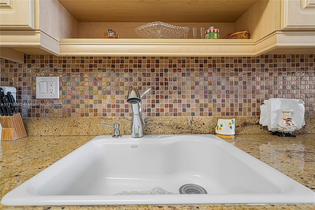 details featuring decorative backsplash, light brown cabinets, and sink