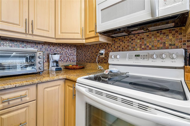 kitchen featuring light stone countertops, white appliances, light brown cabinetry, and tasteful backsplash