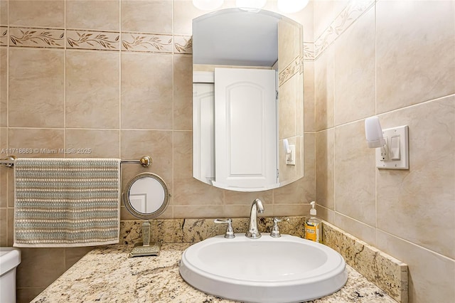 bathroom with sink and tile walls