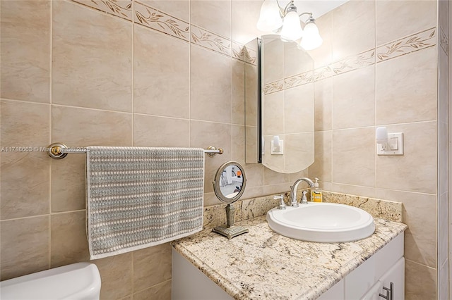 bathroom featuring vanity, toilet, and tile walls