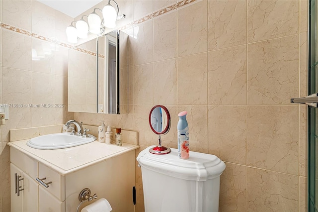 bathroom with vanity, tile walls, and toilet