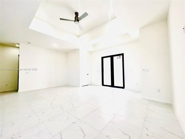 spare room featuring a tray ceiling and ceiling fan