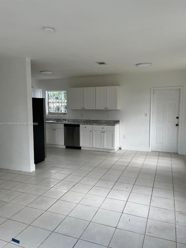 interior space featuring light tile patterned flooring, appliances with stainless steel finishes, sink, and white cabinets