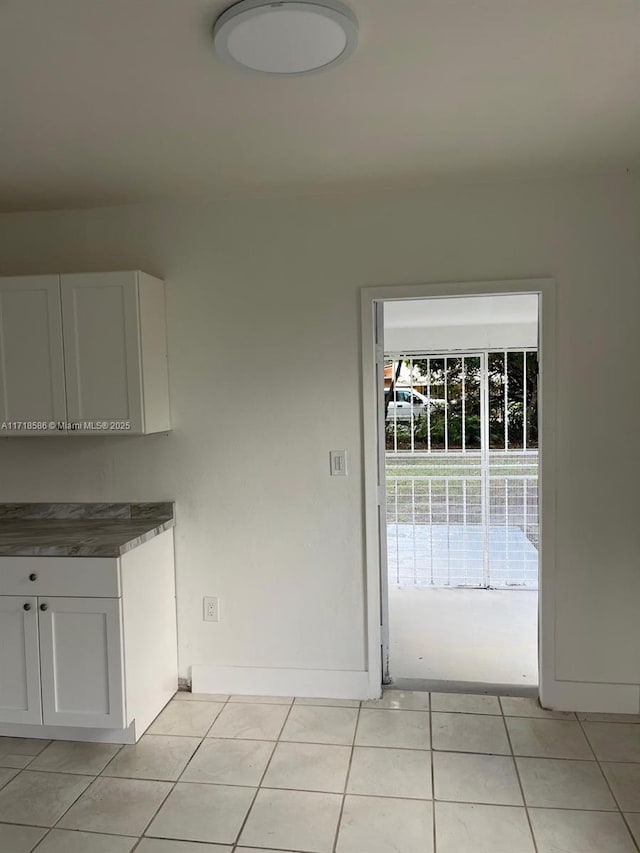 unfurnished dining area with light tile patterned flooring