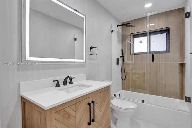 full bathroom with vanity, bath / shower combo with glass door, and toilet