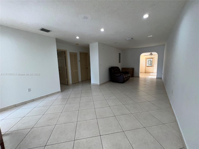 tiled spare room featuring a textured ceiling