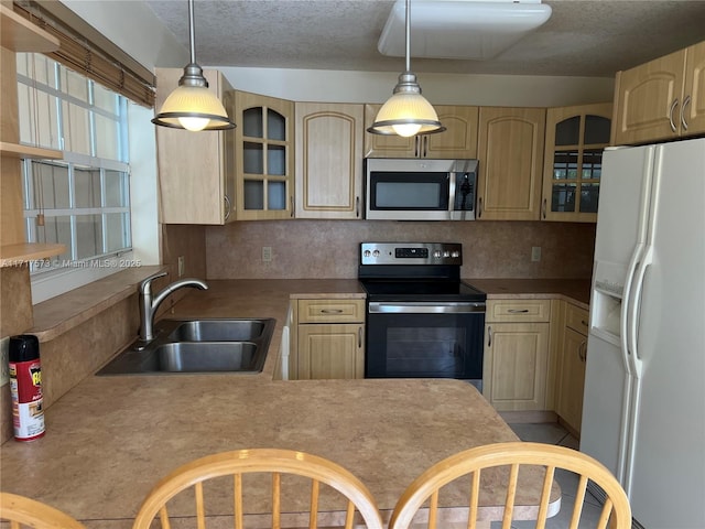 kitchen featuring light brown cabinetry, sink, and appliances with stainless steel finishes